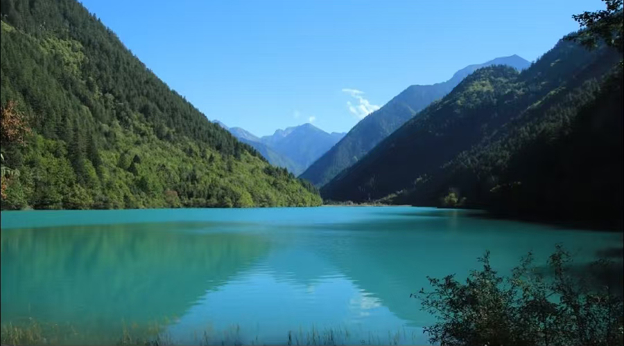Rhinoceros Lake with clear water reflecting mountains and forests